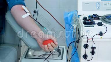 一个人用一个红球在中心<strong>献血</strong>时抽血。